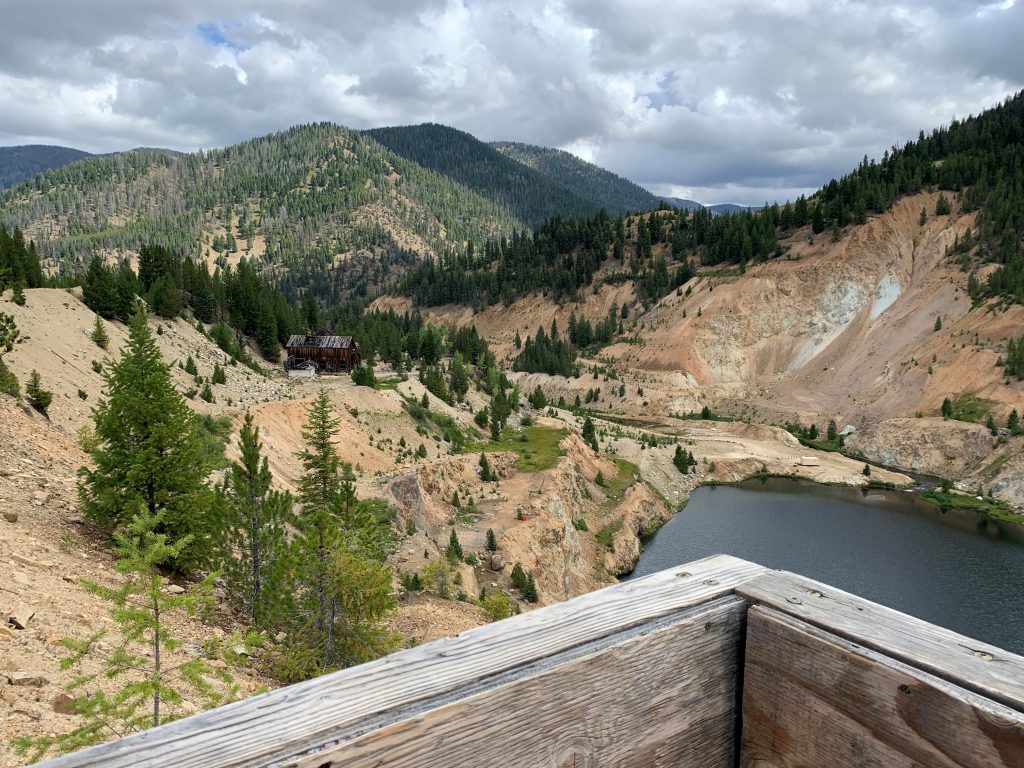 Mine overlooking trees on a hillside and an old cabin