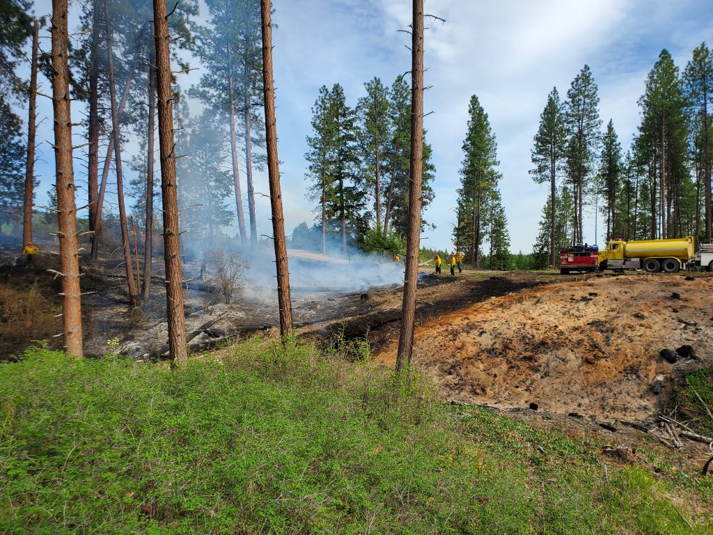 Photo of firefighters containing escaped burn piles fire